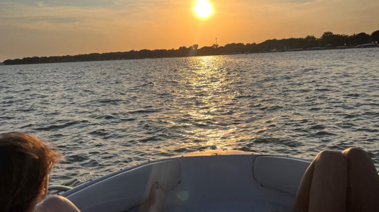 Girls on boat driving into sunset on Clear Lake, IA