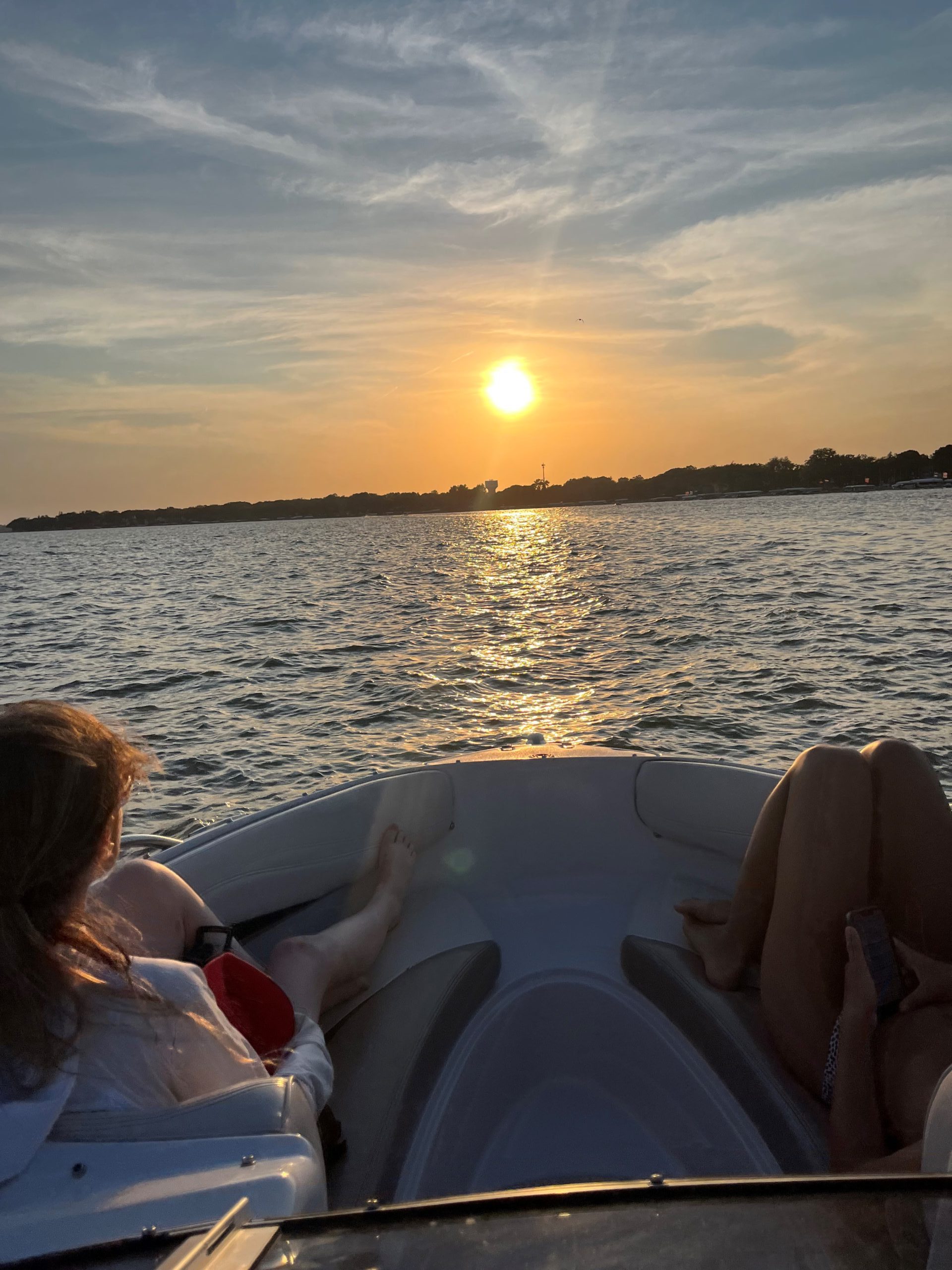 Girls on boat driving into sunset on Clear Lake, IA